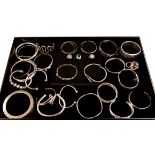 Three stone set contemporary silver rings and thirteen silver bangles all hallmarked or stamped and