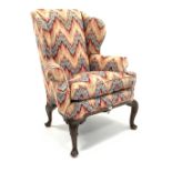 Georgian design wingback armchair, with out swept arms, raised on carved cabriole supports,