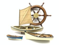 Decorative ships wheel, D63cm and three small models of rowing or fishing boats with oars,