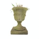 Composite stone single urn, with leaf moulded edge, on square plinth,