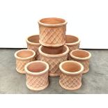 Two sets four cylindrical terracotta planters with latticework design,