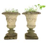 Pair composite stone garden urns on stepped soccle bases,