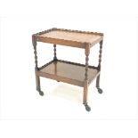 Early 20th century oak two tier tea trolley with spiral turned supports, on castors,