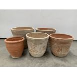 Two near pares of terracotta plant pots with etched decoration,
