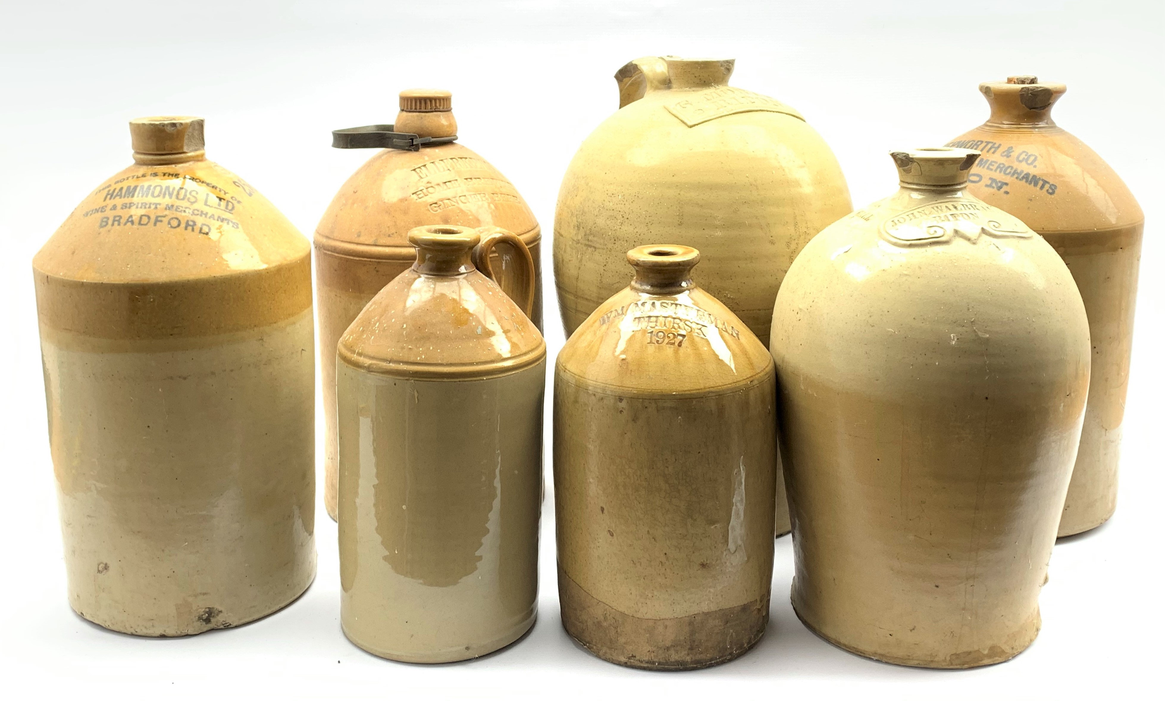 Seven stoneware flagons including large flagon of baluster form stamped 'G.