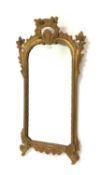 19th century upright wall mirror, the carved gilt wood frame having floral decoration,