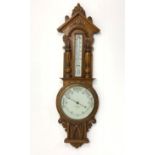Early 20th century carved oak cased with mercury thermometer on white enamel register,