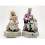 Pair of German seated figures of an elderly man and woman accompanied by a cat and a dog on