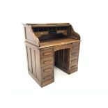 Edwardian oak serpentine roll top desk with fitted interior over central drawer flanked by a pair