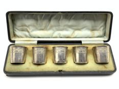 Set of five French silver tot cups with engraved decoration,