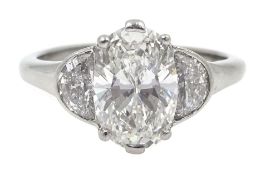 Platinum three stone diamond ring, the oval centre stone of approx 1.