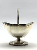 Silver swing handled sugar basket of panel sided design on a pedestal foot London 1909 Maker