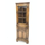 20th century carved oak corner cupboard, dentil cornice over glazed door, panelled door under,