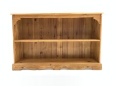 20th century pine bookcase with one fixed shelf, raised on shaped plinth, W123cm, H77cm,