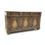 17th century style carved and panelled oak coffer, raised on recessed castors,