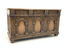 17th century style carved and panelled oak coffer, raised on recessed castors,