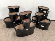 Set of nine black glazed terracotta garden planters, various sizes,