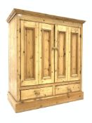 Traditional pine double bifold cupboard enclosing shelf, over two drawers to base,