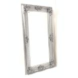 Large 20th century upright wall mirror in ornate swept silver frame, with bevelled plate,