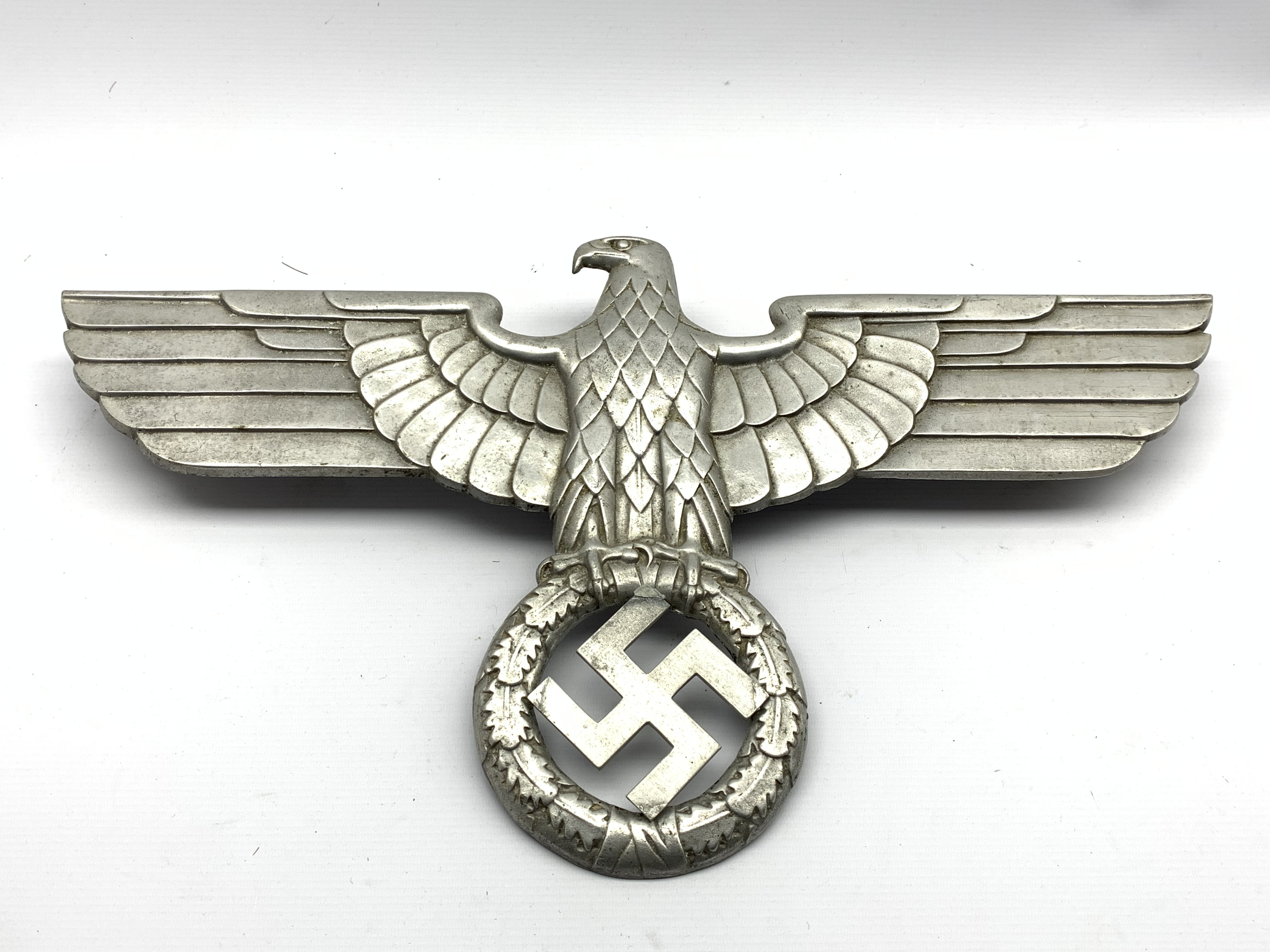 Third Reich Nazi Germany cast metal insignia, eagle with spread wings above wreath,