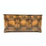 18th century style solid oak dresser base, with three drawers over three cupboards, panelled sides,