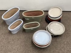 Four glazed terracotta planters and a quantity of glazed terracotta pot plates