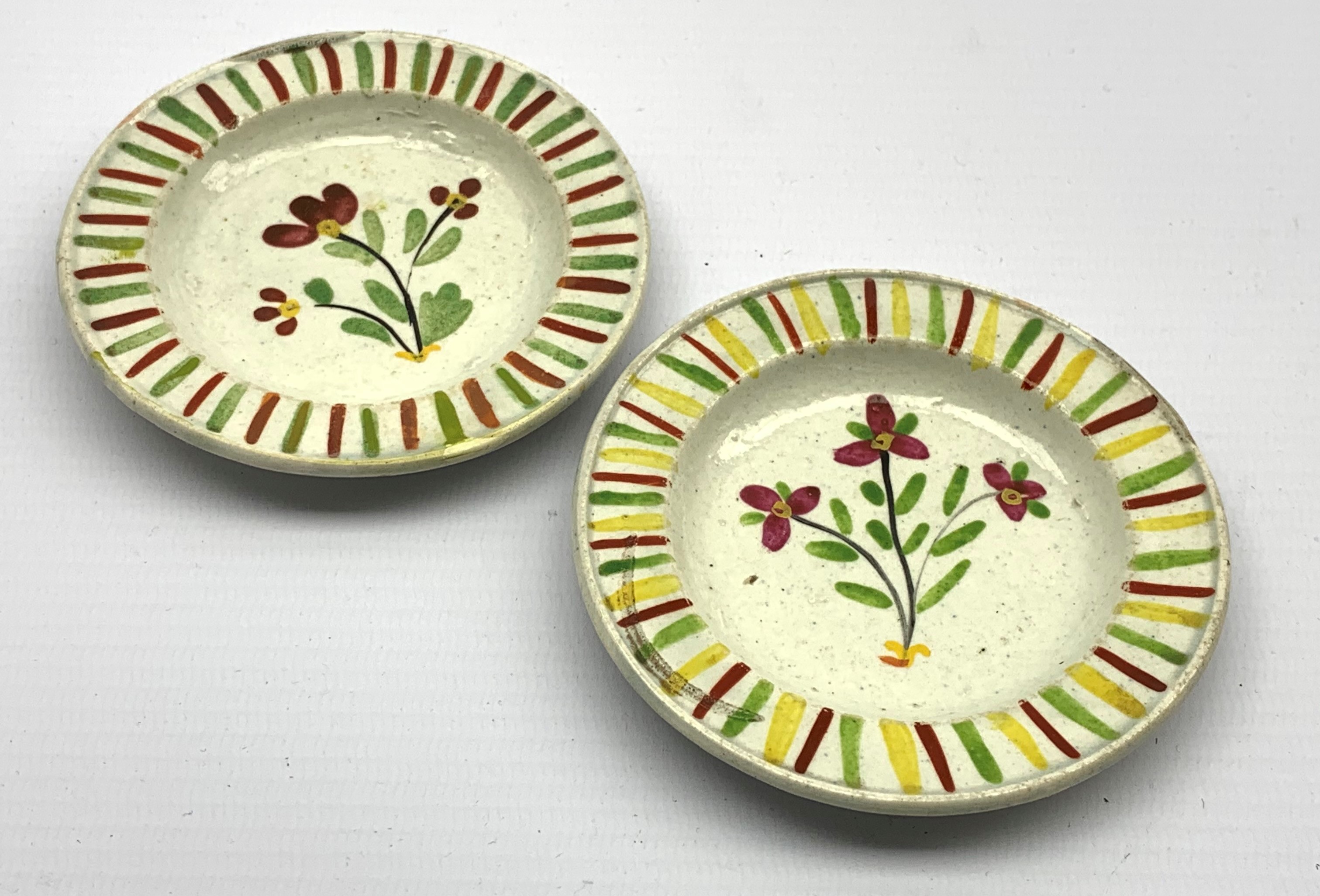 Pair of early 19th Century creamware miniature plates painted with a spray of flowers within a