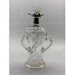 Late Victorian glass decanter of baluster form with three faceted handles,