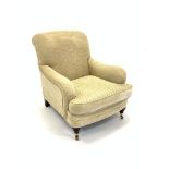 Howard style upholstered armchair, turned mahogany supports and brass cup castors,
