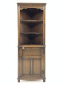 20th century carved oak corner cupboard, with two shaped shelves over panelled door, W62cm, H168cm,