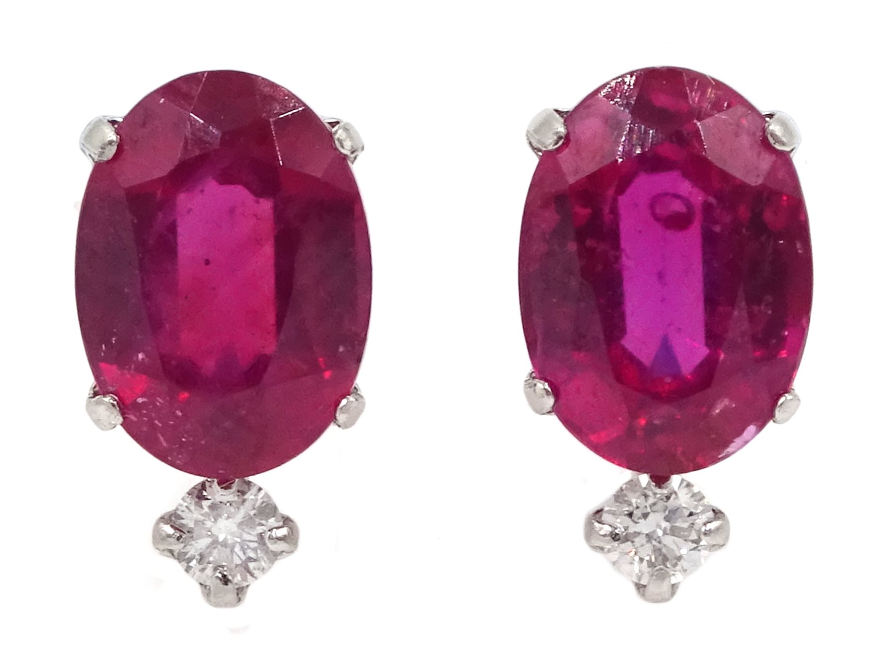 Pair of platinum oval ruby stud earrings, each set with a diamond, stamped Pt 900, ruby total weigh