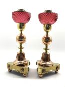 Pair of Victorian Arts and Crafts style brass and copper oil Lamps with cranberry glass reservoirs