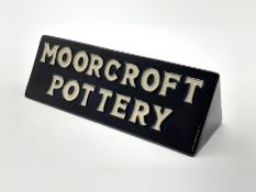 Moorcroft pottery shop display sign of triangular section, both sides reading 'Moorcroft Pottery' i