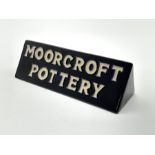 Moorcroft pottery shop display sign of triangular section, both sides reading 'Moorcroft Pottery' i