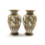 Pair of Doulton Lambeth vases with relief moulded and painted scrolling leaf and flower head decora