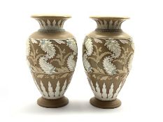 Pair of Doulton Lambeth vases with relief moulded and painted scrolling leaf and flower head decora