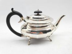 Silver oval teapot of panelled design with ebonised handle and lift on four splay feet Sheffield 193