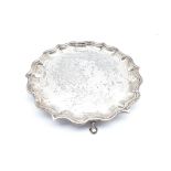 Small silver circular salver with piecrust border and triple shaped supports D20cm marks rubbed but