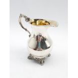 Early Victorian silver cream jug with gilded interior and scroll handle on shaped supports H13cm Lon