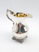 Early Victorian silver cream jug with gilded interior and scroll handle on shaped supports H13cm Lon