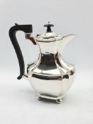 Silver hot water jug of panel sided design with ebonised handle and lift on ball feet H23cm Birmingh