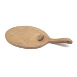 'Mouseman' oak cheeseboard of oval form with raised handle, by Robert Thompson of Kilburn, D56cm, H4