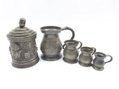 19th Century pewter tobacco jar and cover of cylindrical design cast with scenes from Mr Punch H17cm