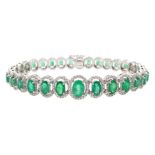 18ct gold graduating oval emerald bracelet, each emerald surrounded by brilliant cut diamonds, total