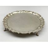 George VI silver salver of circular form with pie crust border, on four hoof feet by Barker Brothers