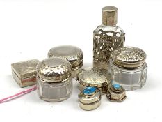 Three small silver pill boxes, two glass jars with silver covers, glass scent bottle with silver cas