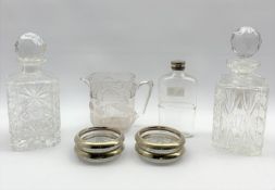 Two square cut glass spirit decanters, set of four Italian glass coasters with plated rims, moulded