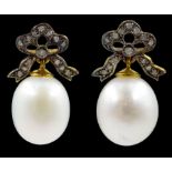 Pair of oval cultured pearl and diamond bow pendant earrings