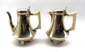 Pair of silver cafe au lait pots of Art Deco design of spreading form with ivory handles on pierced