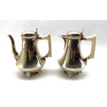 Pair of silver cafe au lait pots of Art Deco design of spreading form with ivory handles on pierced